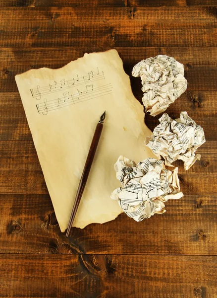 Boules de papier froissées avec stylo à encre et feuille de musique sur fond en bois — Photo