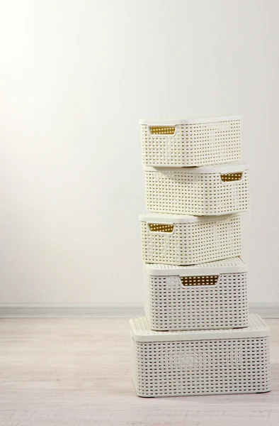 Plastic baskets for storing things in floor on room background