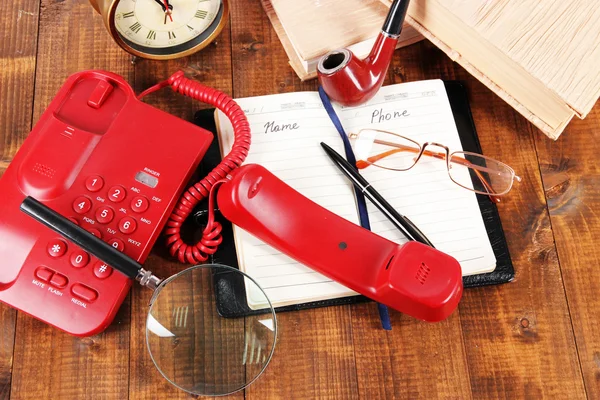 Telefoon en Kladblok en andere items, op houten achtergrond — Stockfoto