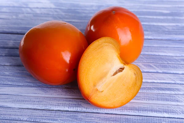 Ripe persimmons on wooden background — Stock Photo, Image