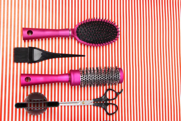 Hairdressing tools on striped red background — Stock Photo, Image