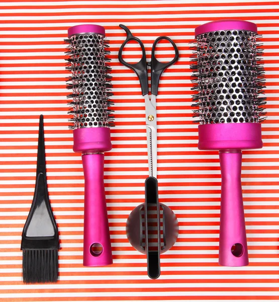 Herramientas de peluquería sobre fondo rojo rayado — Foto de Stock