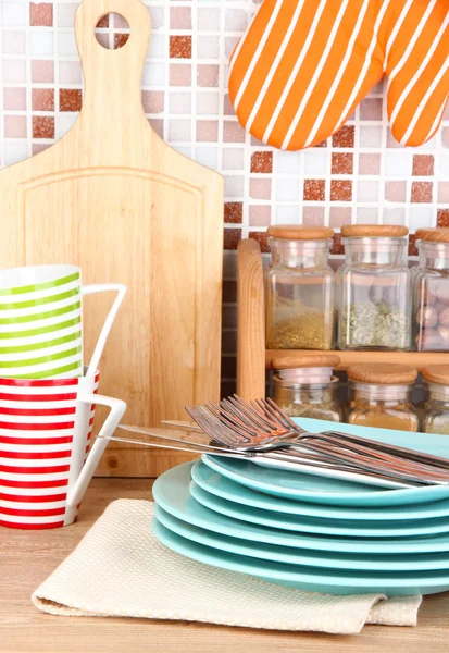 Tableware in kitchen on table on mosaic tiles background — Stock Photo, Image