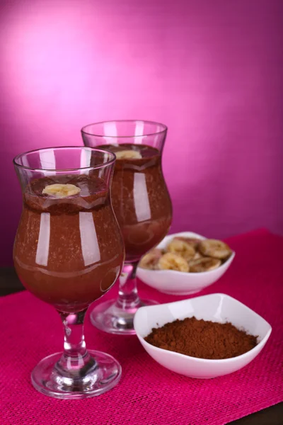 Cócteles con plátano y chocolate sobre mesa sobre fondo morado —  Fotos de Stock