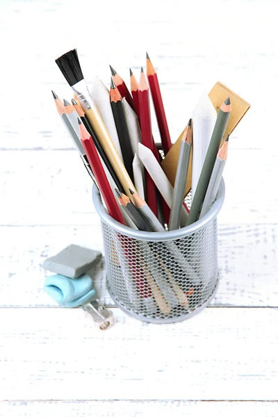 Professional art materials in metal holder, on wooden table — Stock Photo, Image