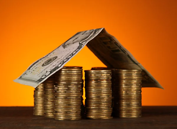 Casa de moedas na mesa no fundo marrom — Fotografia de Stock