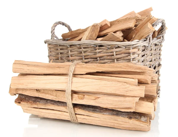 Stack of firewood in wicker basket isolated on white — Stock Photo, Image