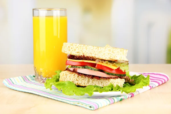 Frisches und schmackhaftes Sandwich auf Teller auf Tisch vor hellem Hintergrund — Stockfoto