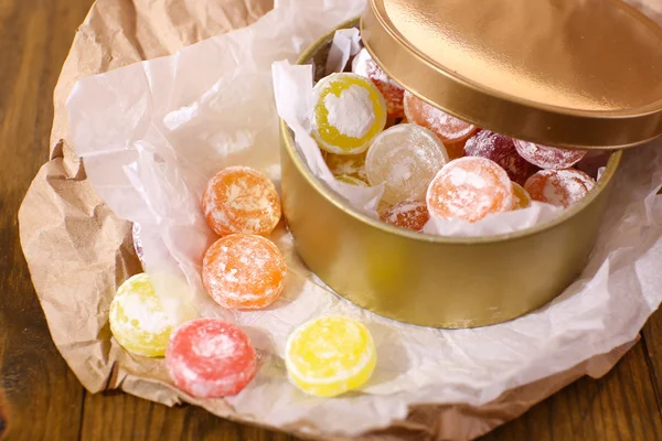 Sweet candies in metal can, on wooden background — Stock Photo, Image