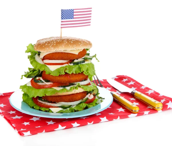Composition with huge burger on color plate and USA flag, isolated on white — Stock Photo, Image