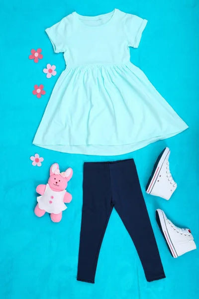 Beautiful clothes for little girl on blue background — Stock Photo, Image