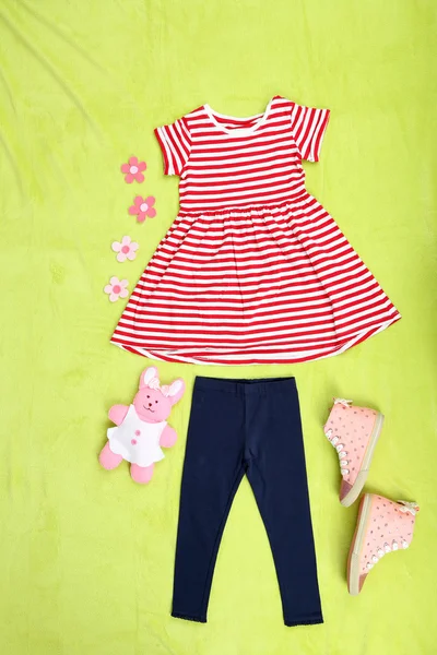 Vackra kläder för liten flicka på grön bakgrund — Stockfoto