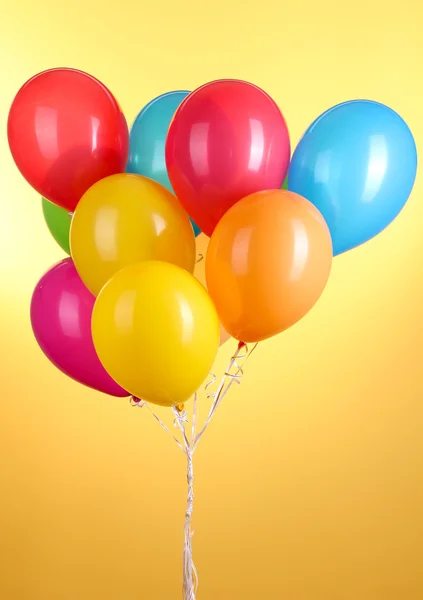 Färgglada ballonger på gul bakgrund — Stockfoto