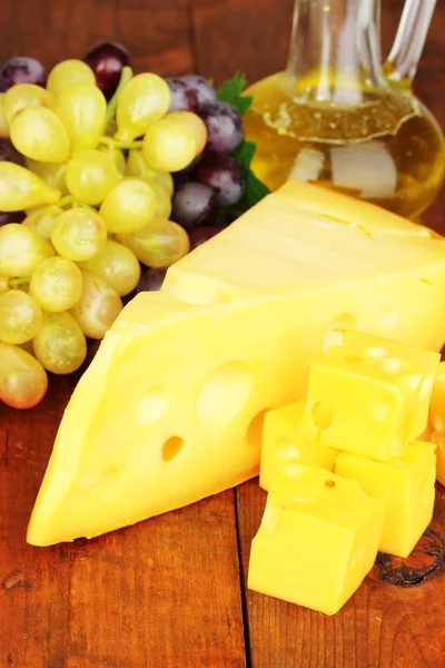 Cut cheese with grape on wooden table — Stock Photo, Image