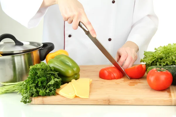 Mains féminines coupant des légumes, isolées sur blanc — Photo