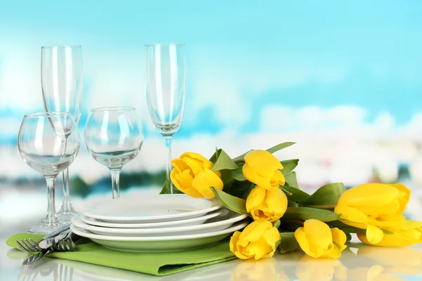 Gele tulpen en gebruiksvoorwerpen voor portie op blauwe natuurlijke achtergrond achtergrond — Stockfoto