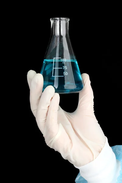 Glass tube with fluid in scientist hand during medical test on black background — Stock Photo, Image