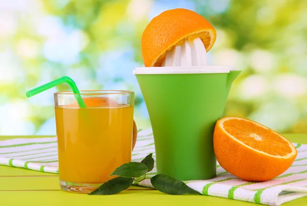 柑橘類を押して、ジュースと熟したオレンジ白い木製のテーブルの上のガラス — ストック写真