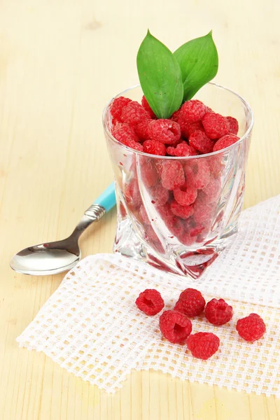 Reife Himbeeren im Glas auf Holztisch in Großaufnahme — Stockfoto