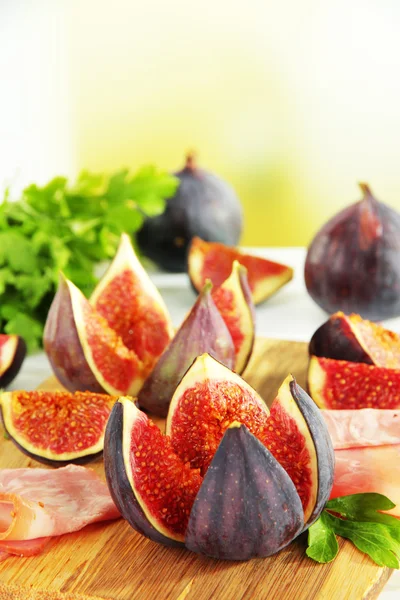 Tasty figs with ham on table — Stock Photo, Image