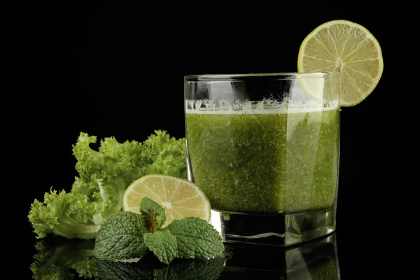 Gelas jus sayuran hijau dan kapur diisolasi pada hitam — Stok Foto