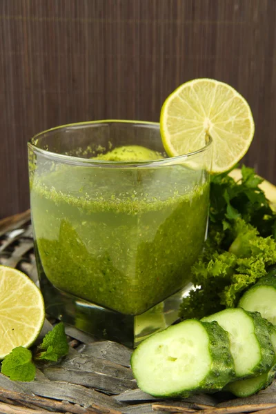 緑の野菜ジュースとキュウリ竹背景にテーブルの上のガラス — ストック写真