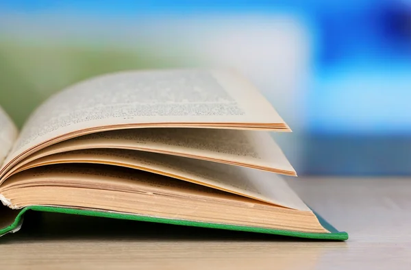 Opende boek op houten tafel op lichte achtergrond — Stockfoto