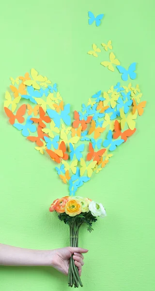 Paper butterflies fly out of flowers on green wall background — Stock Photo, Image