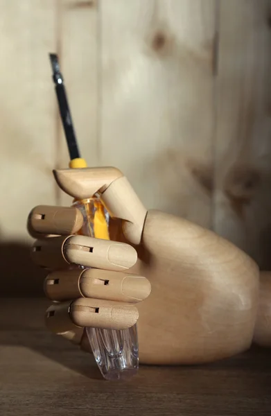 Screwdriver in wooden hand on wooden background — Stock Photo, Image