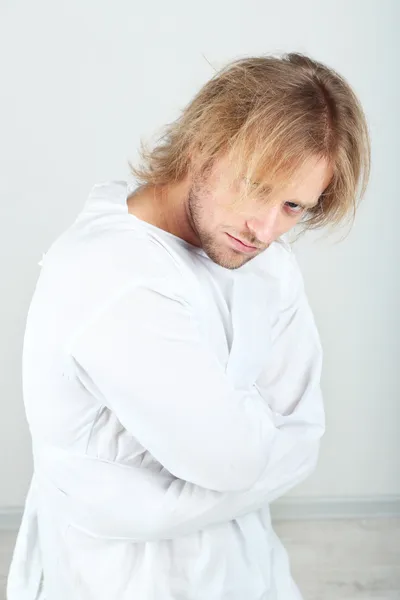 Hombre mentalmente enfermo con camisa de fuerza sobre fondo gris — Foto de Stock