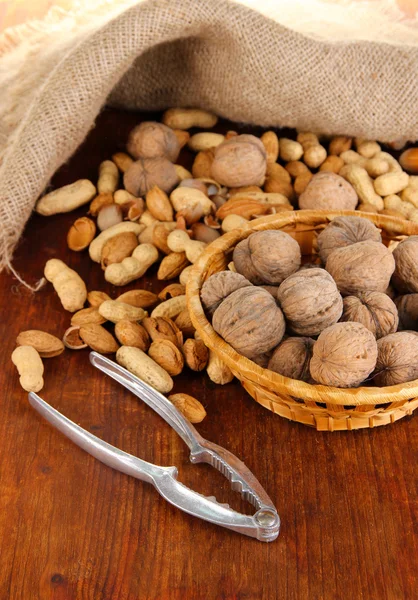 Nussknacker mit Nüssen auf Holztisch in Großaufnahme — Stockfoto