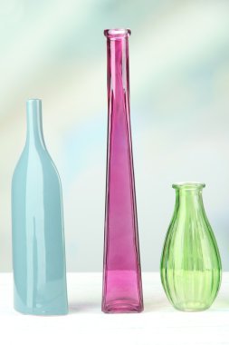 açık renkli raf üzerinde farklı dekoratif vazolar