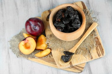 ahşap zemin üzerine peçete üzerinde ahşap kase taze ve kuru erik