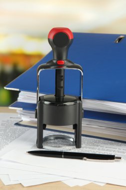 damga ile kağıtları masaya parlak arka plan üzerinde