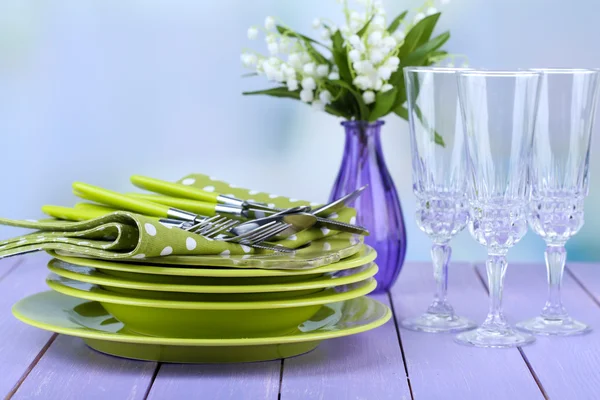 Sauberes Geschirr auf Holztisch auf hellem Hintergrund — Stockfoto