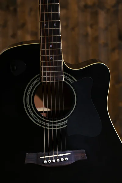Акустическая гитара на деревянном фоне — стоковое фото