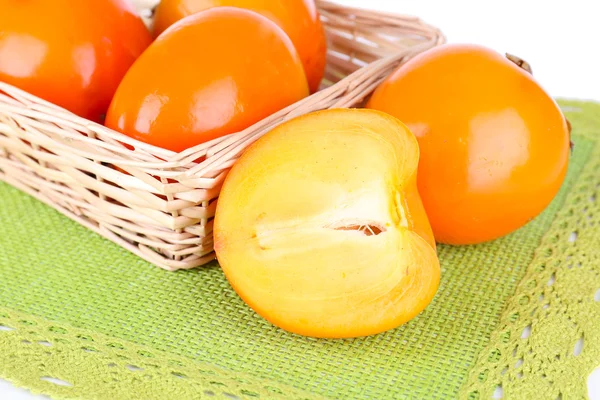 Persimmons mûrs dans un panier en osier sur la table close-up — Photo