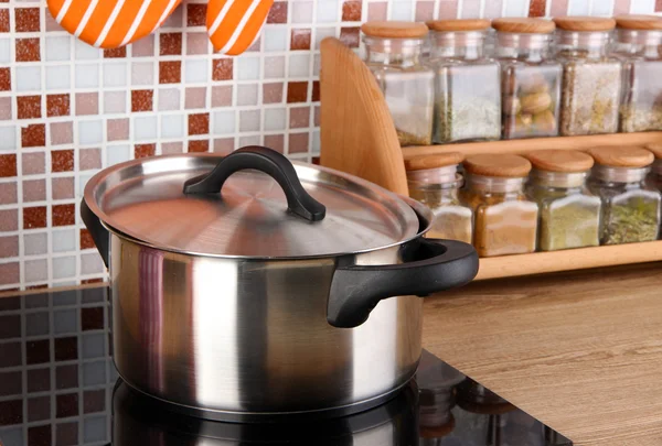 Maceta en la estufa en la cocina en la mesa en el fondo de mosaico azulejos — Foto de Stock