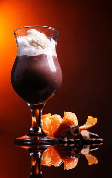 Sobremesa saborosa com chocolate, creme e molho de laranja, no fundo de cor escura — Fotografia de Stock