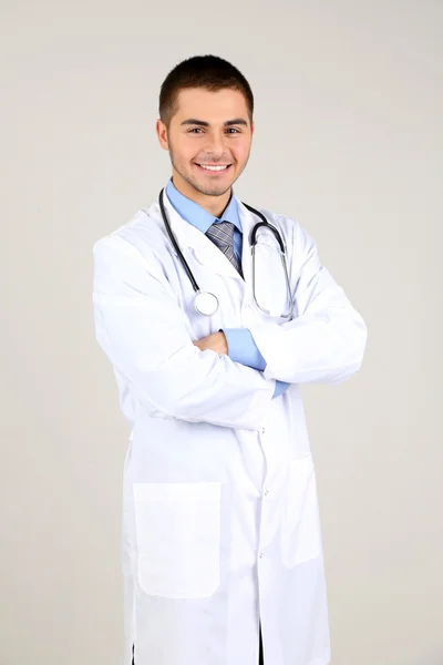 Male Doctor standing on gray background — Stock Photo, Image