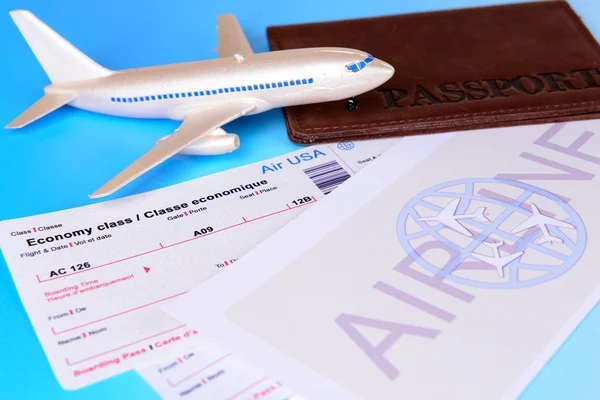 Billetes de avión con pasaporte sobre fondo azul claro — Foto de Stock