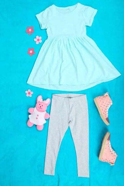 Beautiful clothes for little girl on blue background — Stock Photo, Image