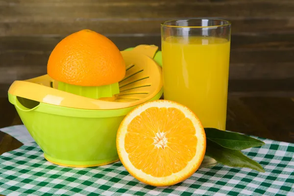 Citrus press and oranges on table on wooden background — Stock Photo, Image