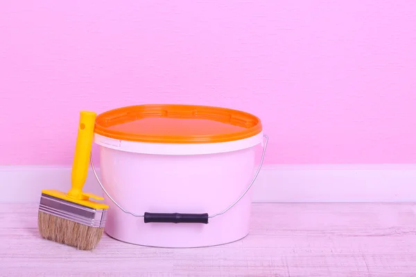 Paint and paintbrush on floor in room on wall background — Stock Photo, Image