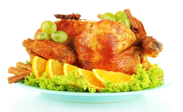 Pollo asado entero con lechuga, uvas, naranjas y especias en plato azul aislado sobre blanco — Foto de Stock