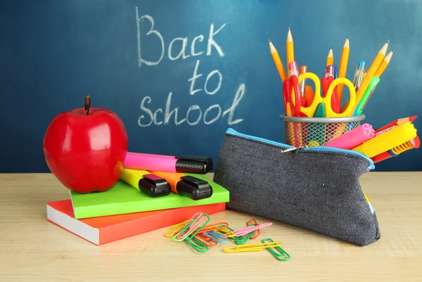 Zurück zur Schule - Tafel mit Bleistiftkasten und Schulutensilien auf dem Tisch — Stockfoto