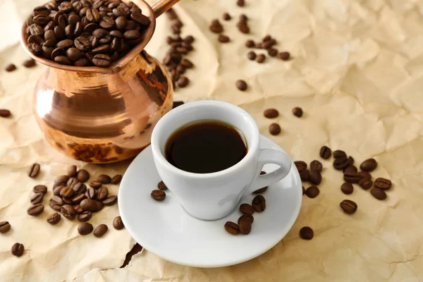Xícara e panela de café no fundo bege — Fotografia de Stock