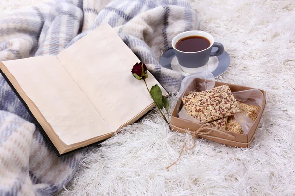 Samenstelling met warme plaid, boek, kopje warme drank op tapijt achtergrondkleur — Stockfoto