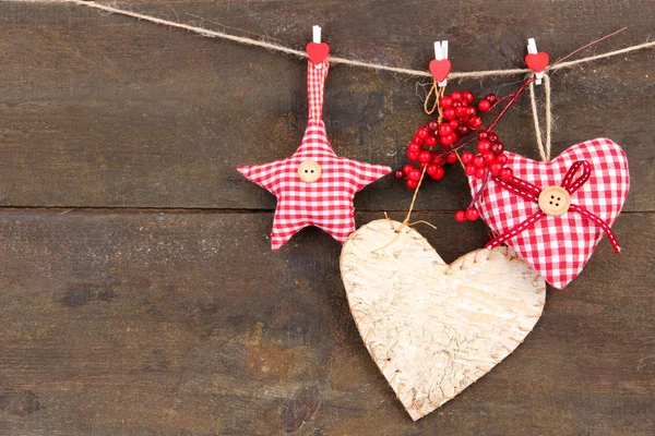 Decoratieve hart en ster op touw, op houten achtergrond — Stockfoto