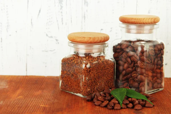 Jars of different coffee on table on wooden background — Stock Photo, Image